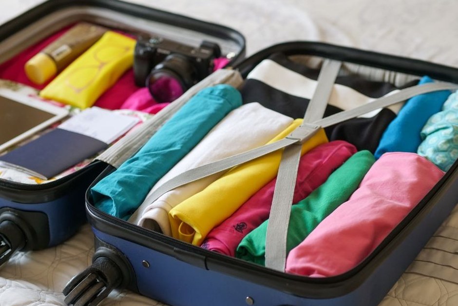 An open suitcase packed neatly for a short weekend trip