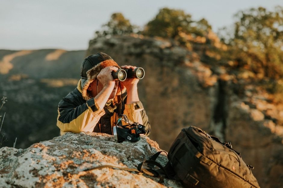 A photographer using a camera from a rocky overlook